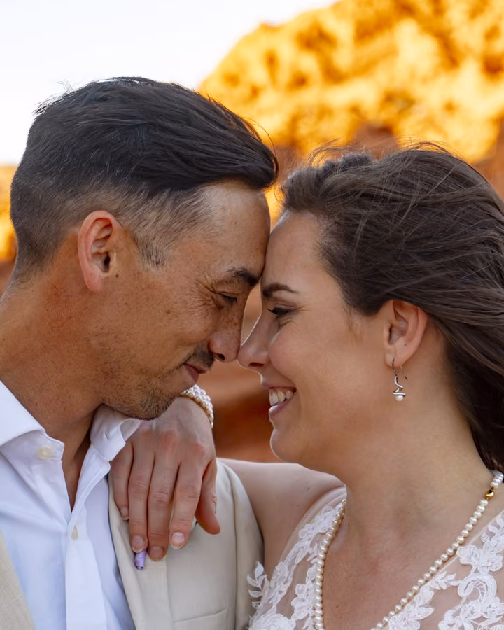 A bride and groom touch foreheads in golden-hour light during their Valley of Fire elopement near Las Vegas.